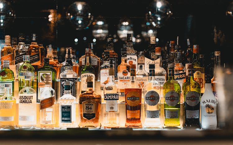 Bottles Of Alcohol On Illuminated Shelf