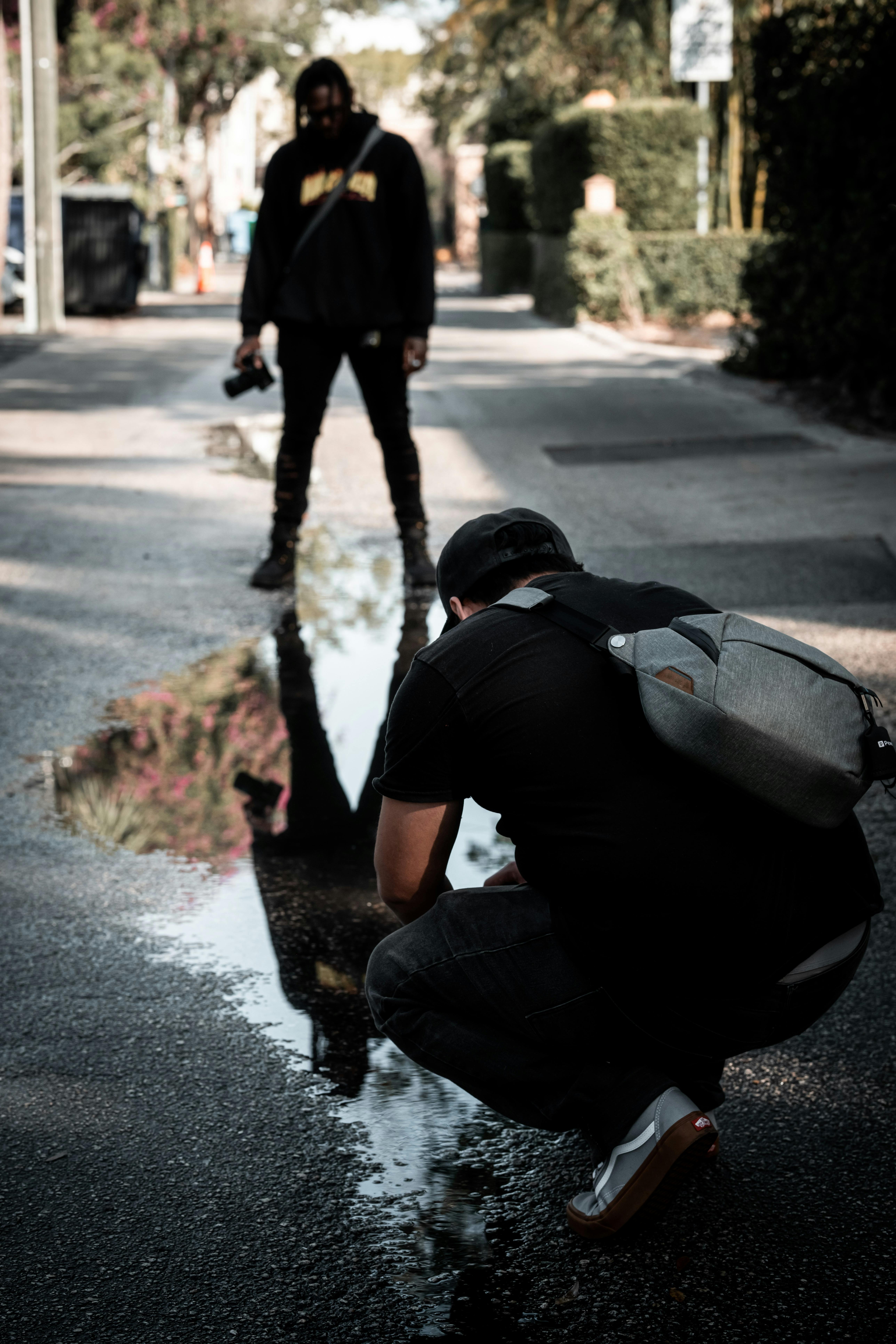 a man kneeling down in the middle of a puddle