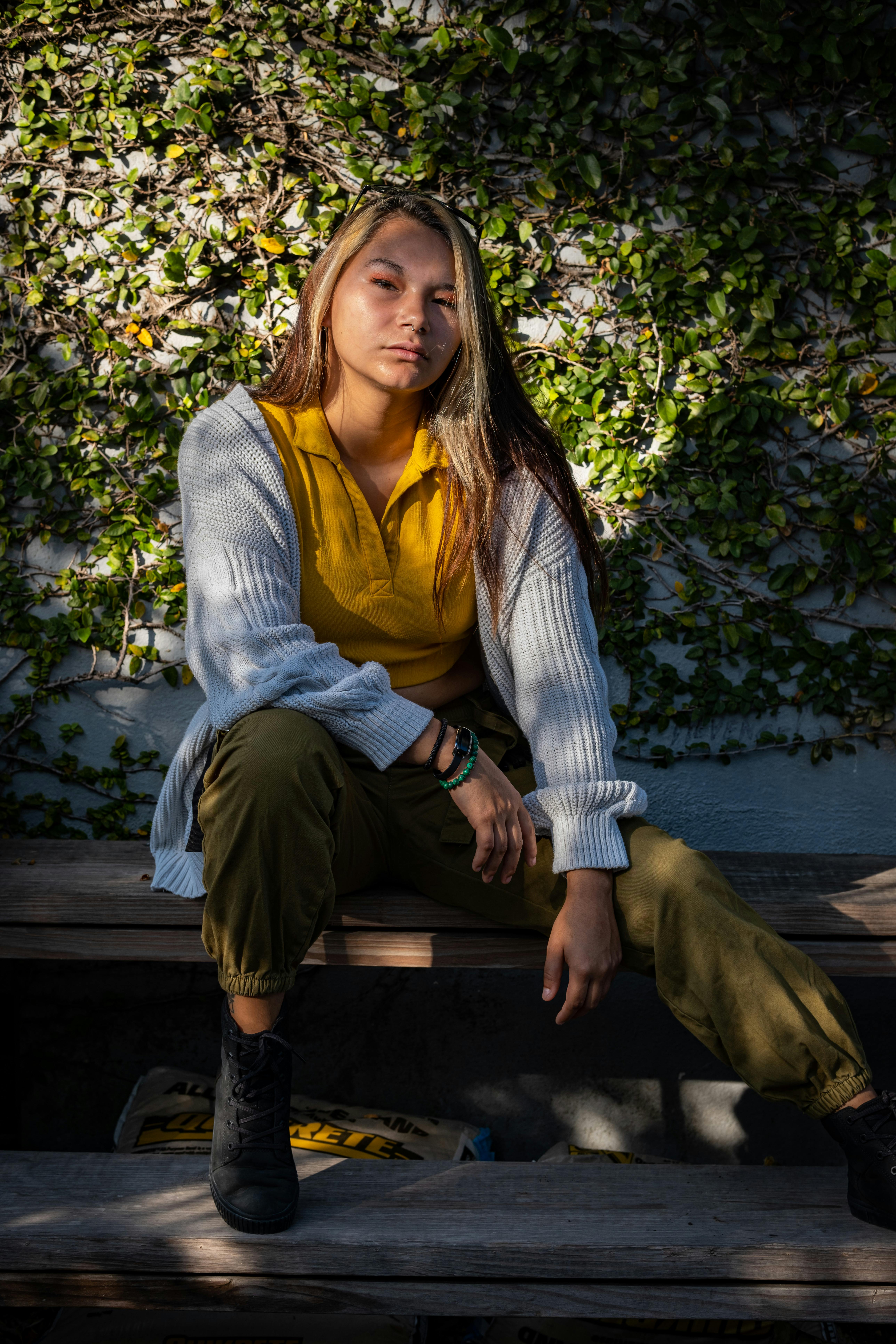 a woman sitting on a bench in front of a wall