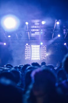 Dynamic crowd with vibrant lights at a nighttime concert, showcasing an energetic atmosphere.