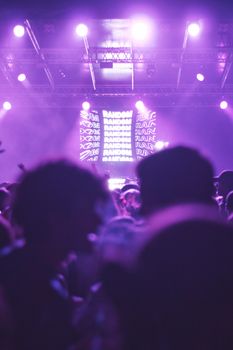 A lively party atmosphere in a nightclub with a DJ and vibrant lighting.