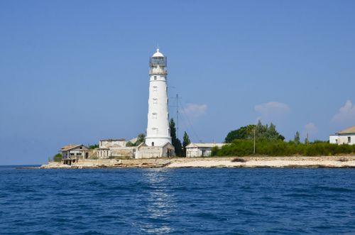 Free Scenic view of Tarkhankut Lighthouse with a clear blue sky and calm sea in the background. Stock Photo
