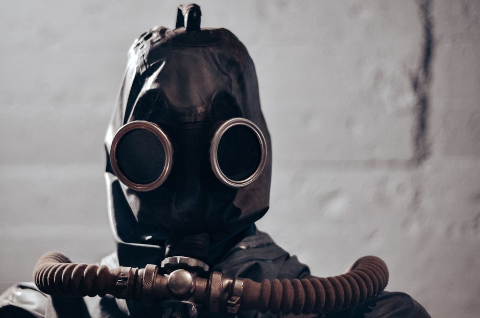 Dramatic portrait of an individual wearing a gas mask, evokes themes of protection and secrecy.