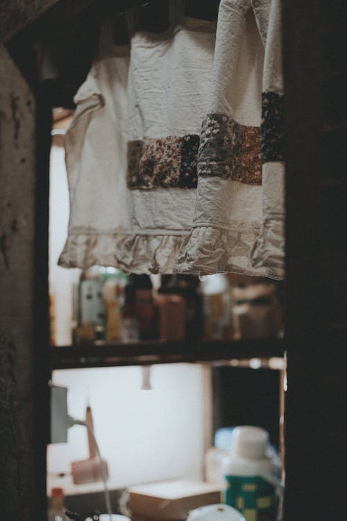 Free Studio Window with a Curtain Hanging, and Bottles on Shelves  Stock Photo