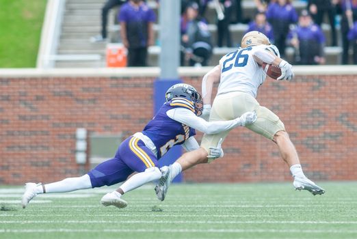 Action-packed capture of a dramatic tackle in an American football game, showcasing athletic skill.
