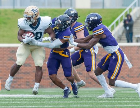 College football players in action on the field, showcasing teamwork and competition.