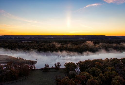 A breathtaking aerial view of a misty lake at sunrise near Ella, Wisconsin, showcasing nature's beauty.
