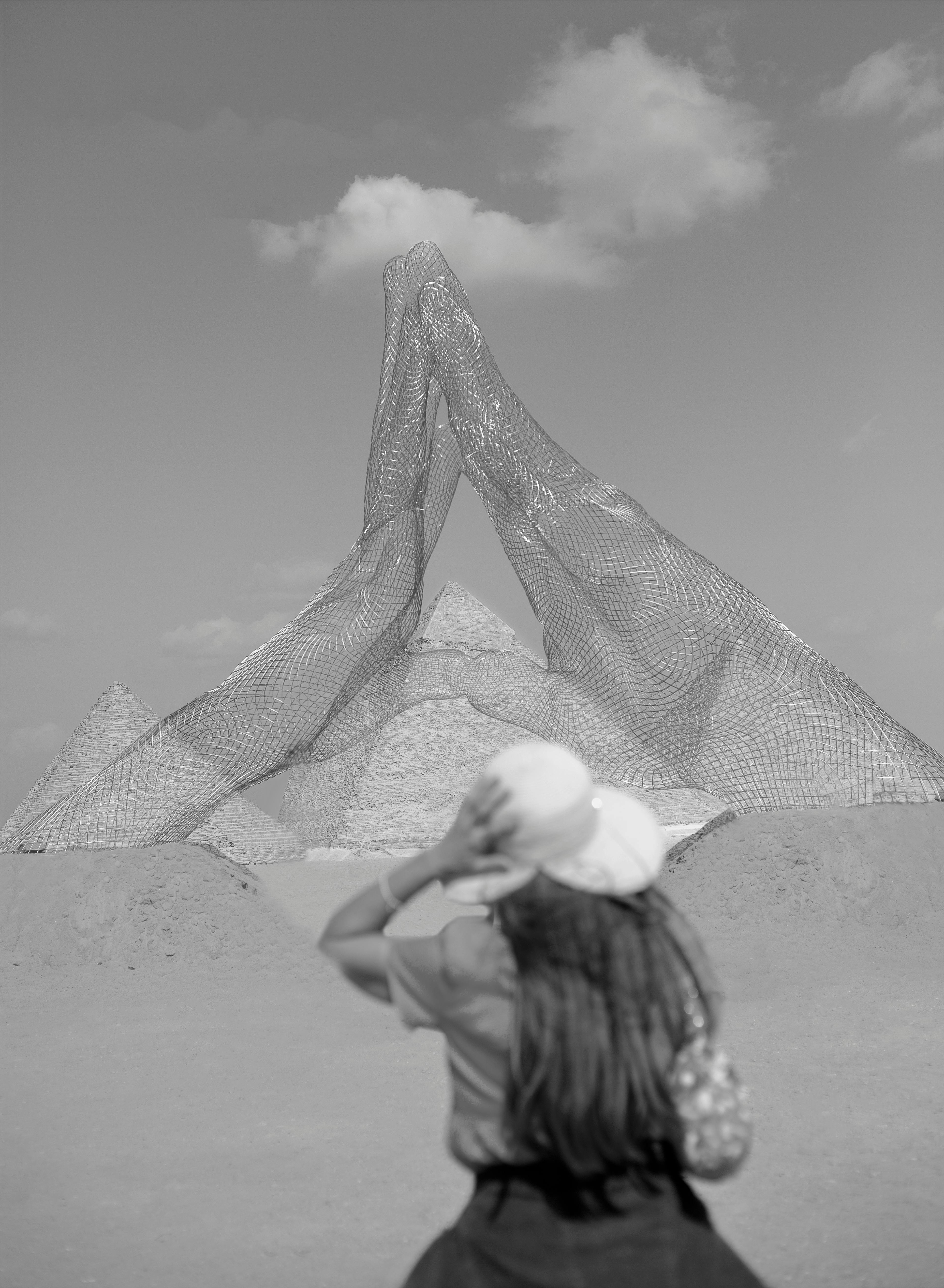 Black-and-white photo of tourist viewing the Great Pyramid in Giza with artistic installation in foreground.