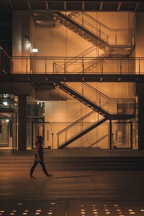 Free A stunning urban night scene in Istanbul featuring a woman walking by a modern building. Stock Photo