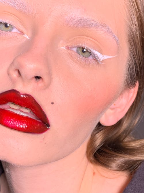 Close Up Photo of Woman Wearing Eye Makeup and Red Lipstick