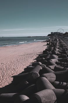 Serene view of Sokcho Beach's shoreline with tetrapods and a distant Ferris wheel in South Korea.