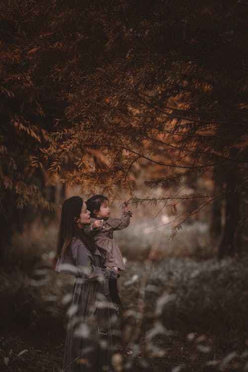 Mother Holding Child under Tree