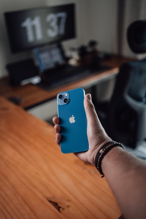 Close-up of Man Holding a Blue iPhone 13 