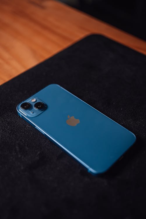 Photos gratuites de Un Iphone bleu sur la table