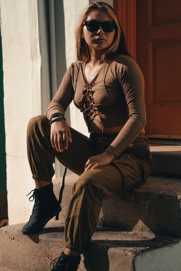 Woman wearing a hazelnut sweater with cargo pants