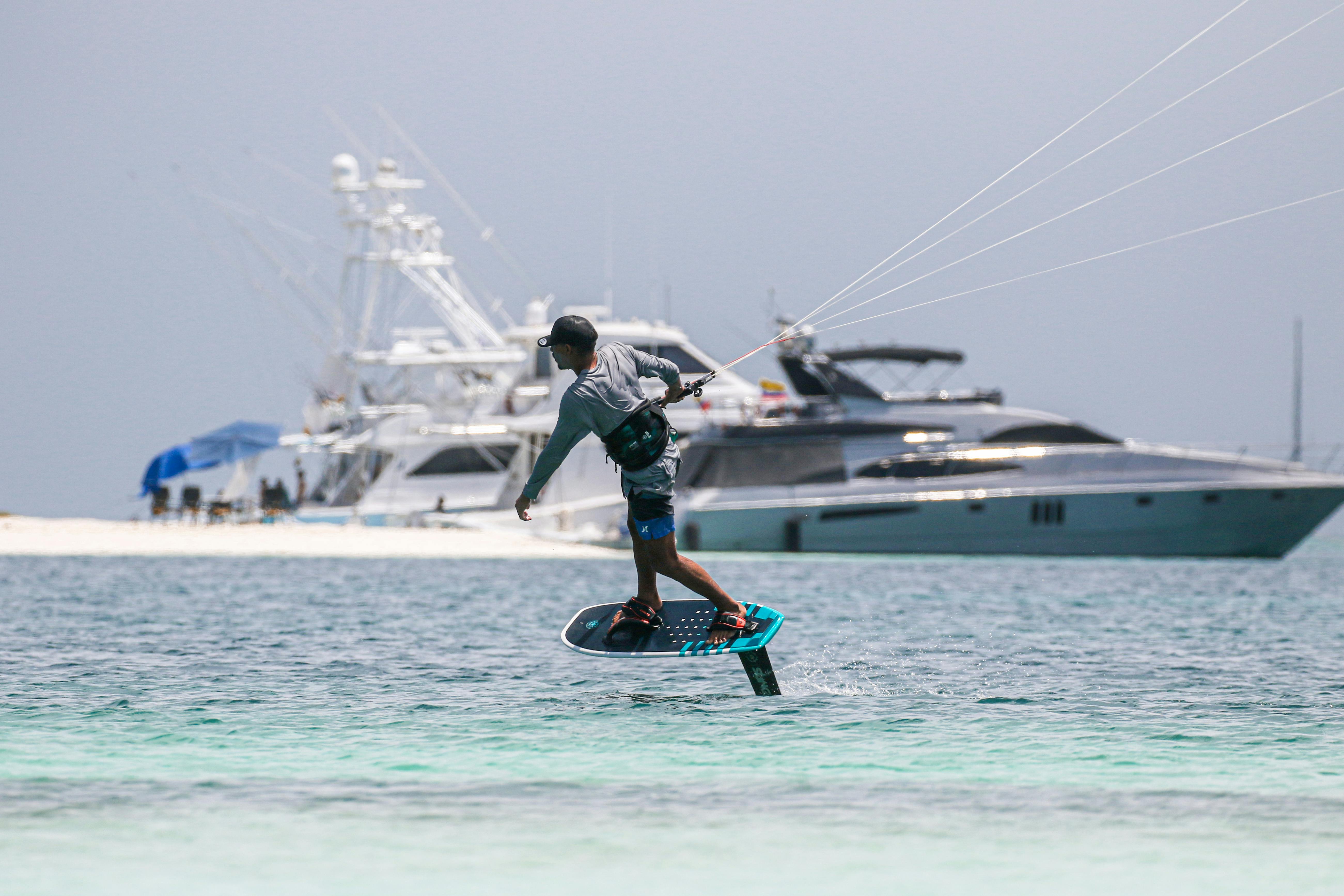 Man Kitesurfing near Motor Yachts · Free Stock Photo