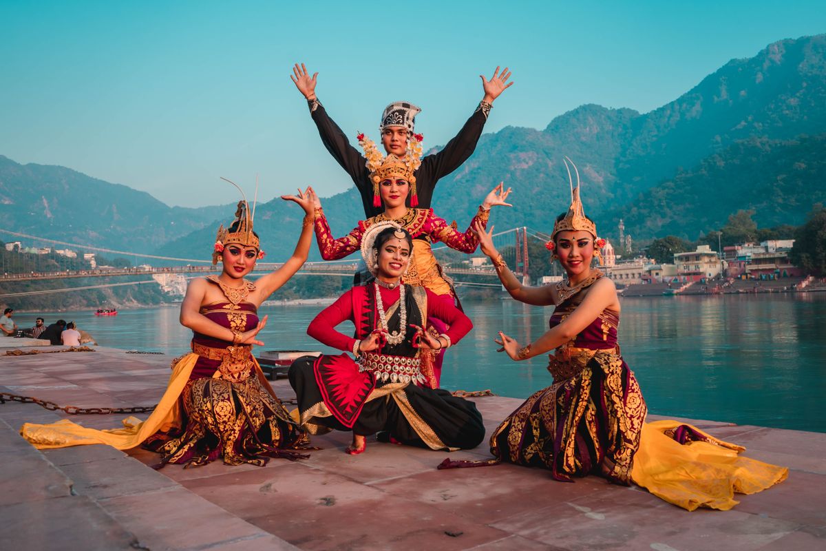 Traditional dancers performing together by the river in Rishikesh, India