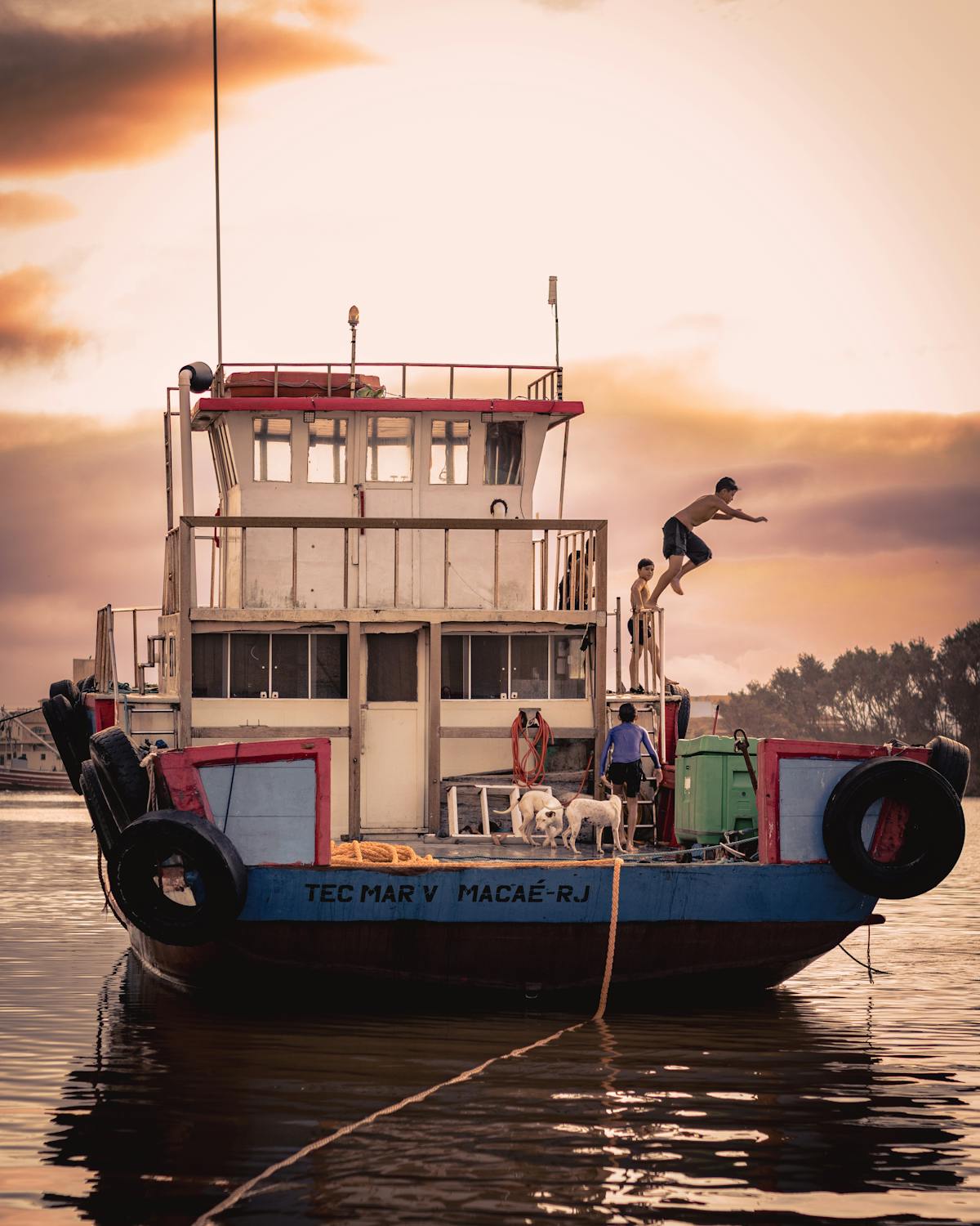 People jumping into a lake from a dock — the summer sauna cold plunge, leaping straight from the hot bastu into the water