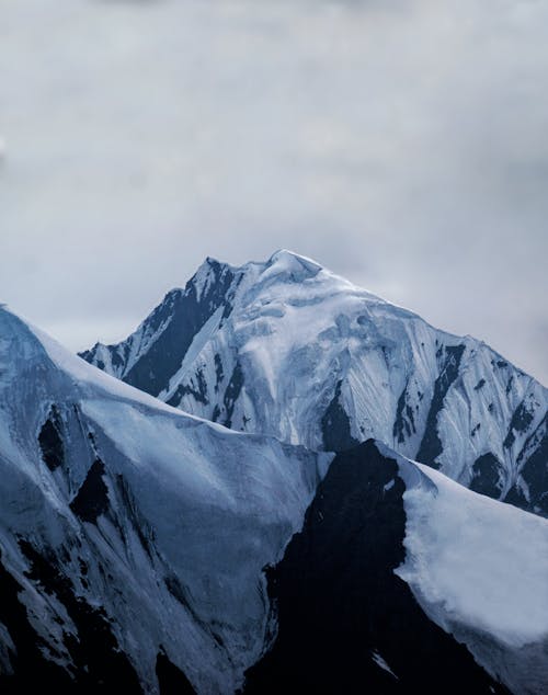 View of Snowcapped Mountains under a Cloudy Sky