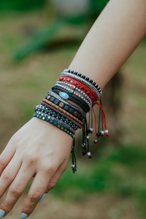 Free Close-up of a woman's hand showcasing colorful bracelets in an outdoor setting. Stock Photo