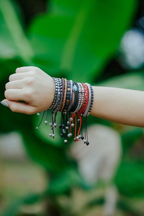 Close-up of Womans Arm with a Bunch of Woven Bracelets