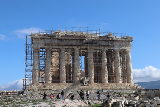 The Parthenon undergoing restoration with scaffolding against a clear blue sky in Athens.