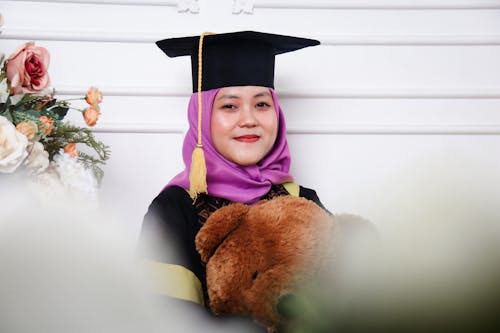 A Woman in Purple Hijab Wearing Her Graduation Cap 