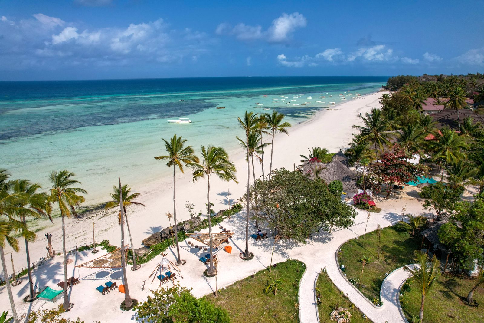 Aerial view of a white-sand beach, palm trees and turquoise water in Zanzibar, Tanzania