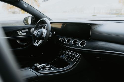 Free Elegant interior of a black luxury car showcasing a modern dashboard and leather trim. Stock Photo
