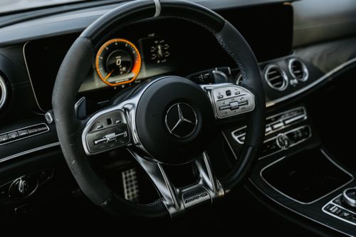 Free Close-up view of a luxury Mercedes car interior showcasing the steering wheel with controls and dashboard. Stock Photo