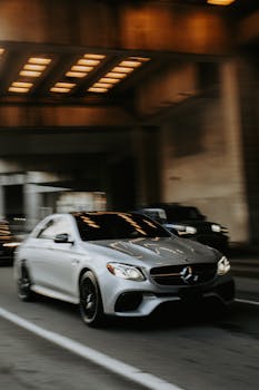 Dynamic shot of a Mercedes-Benz car in motion under a city tunnel at night.