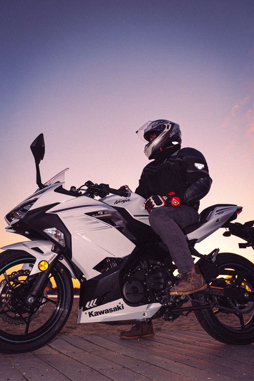 Free Motorcyclist on a Kawasaki Ninja bike at sunset, showcasing adventure and freedom. Stock Photo