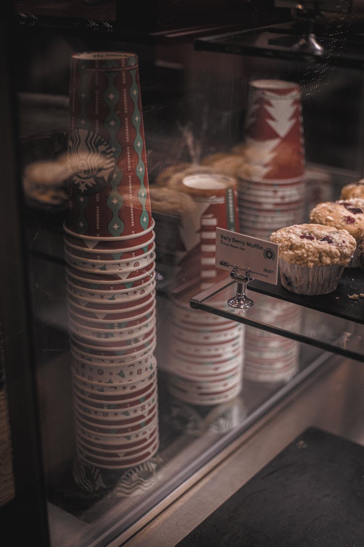 Close-up Of Pastries And Cups Inside A Display Shelf