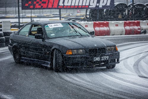 Black Car Drifting on the Snowy Speedway