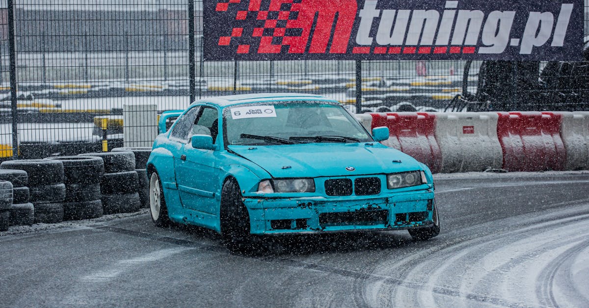 A blue BMW performing a drift on a snowy race track, demonstrating automotive control.