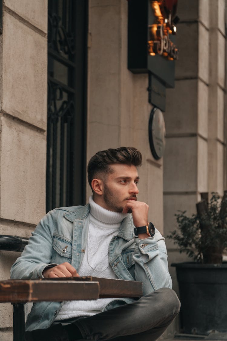 Man In Jacket Sitting By Table