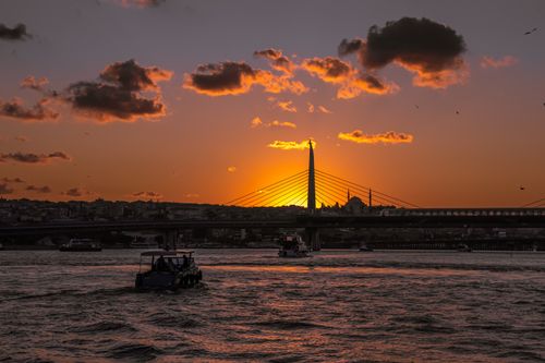 Free Stunning sunset view over the Golden Horn in Istanbul, Turkey, featuring boats and cityscape silhouette. Stock Photo