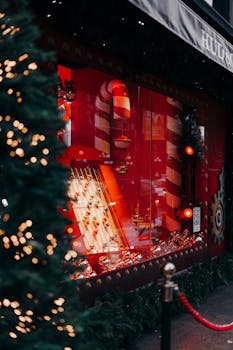 A vibrant red Christmas window display with candy cane decor and festive lights.