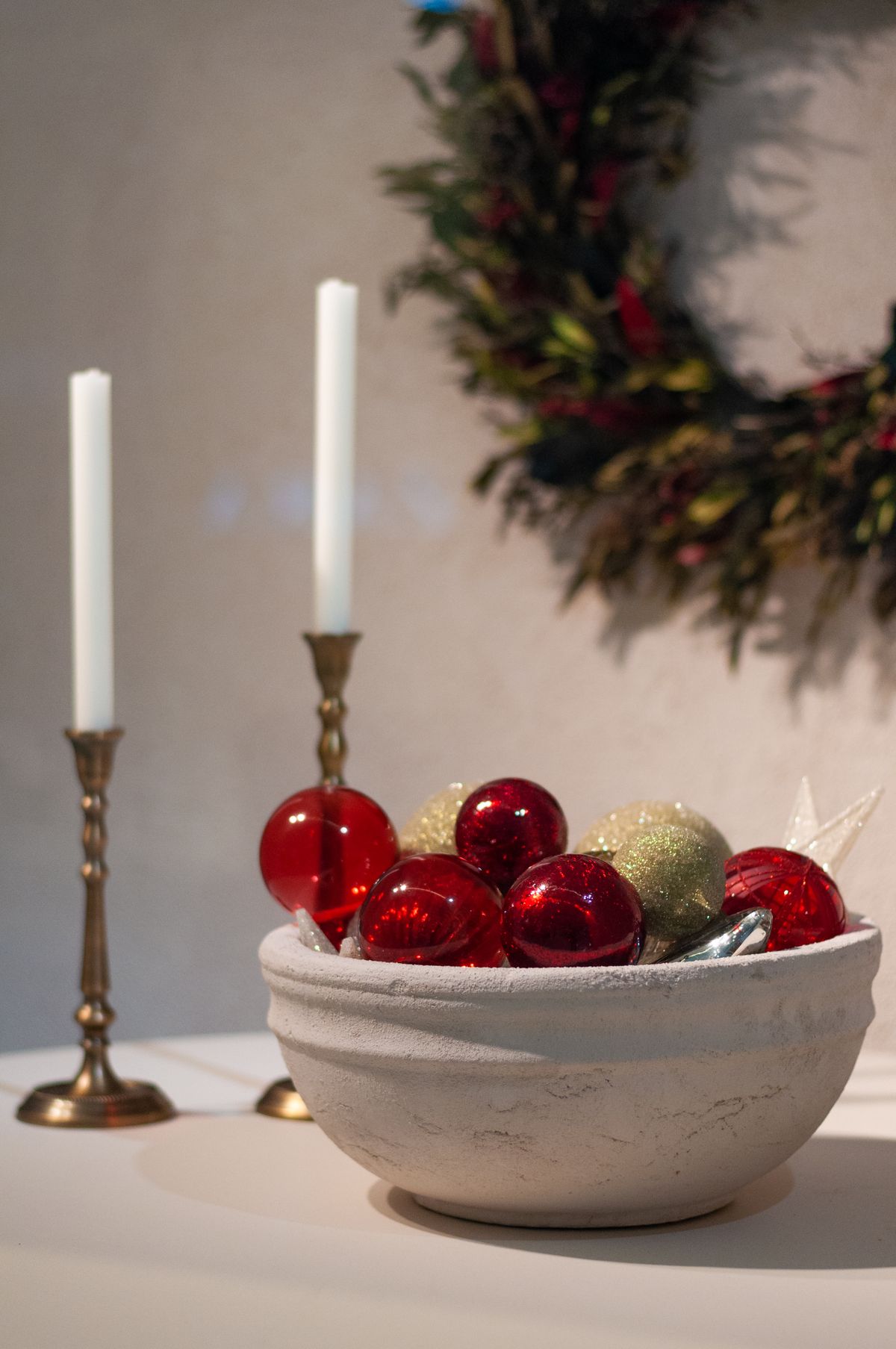 Festive centerpiece with Christmas balls in a bowl and candles
