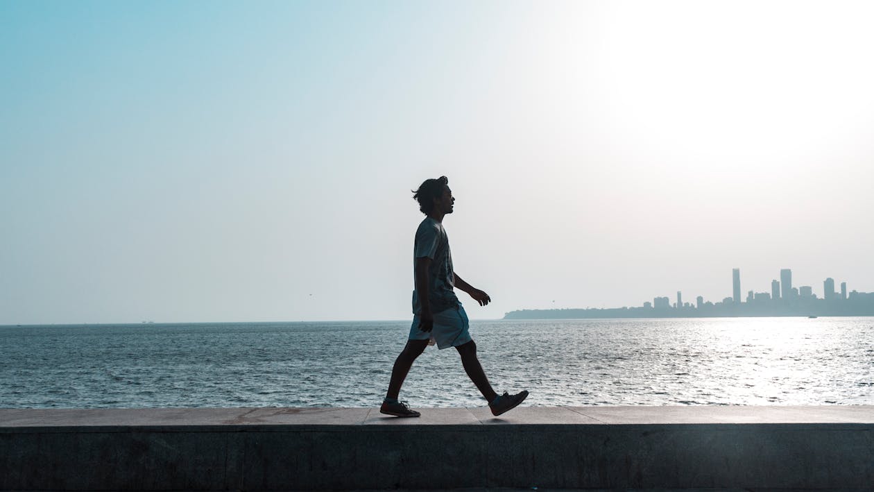 Man Walking Near Body of Water