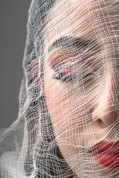 Close-up portrait of a woman with bold makeup and gauze overlay from Bogotá, Colombia.