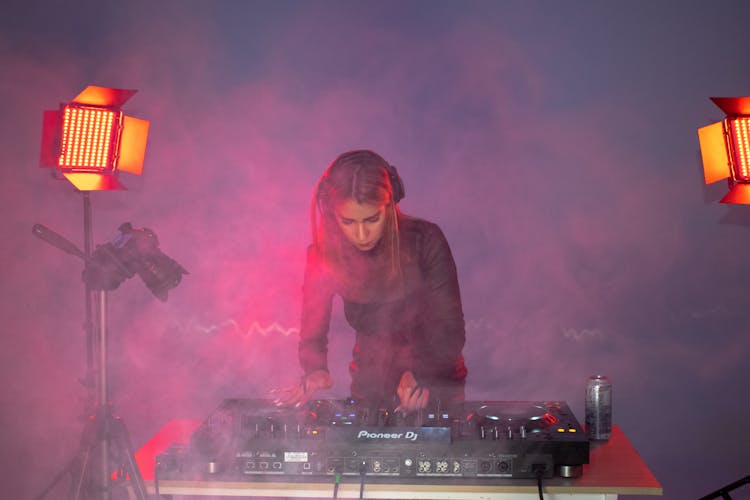 A Woman In Black Jacket Playing DJ Mixer