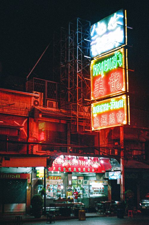 Free Illuminated neon signage on a bustling street in Bangkok at night. Vibrant city life captured. Stock Photo
