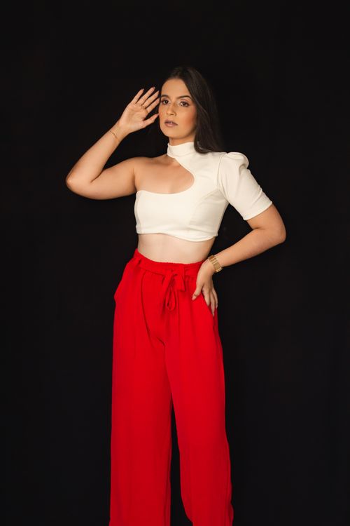 Free Stylish woman in modern outfit posing in studio against a black background. Stock Photo