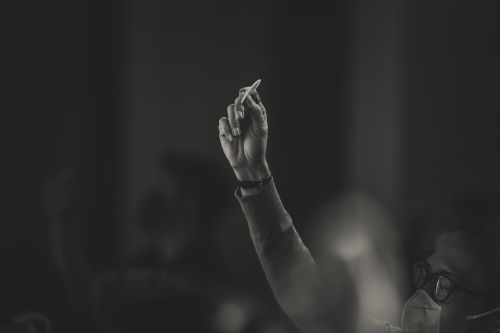 Free A thoughtful hand gesture by a masked person in a dimly lit setting, emphasizing contemplation. Stock Photo