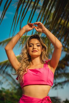 Stylish young woman enjoying a tropical summer under palm trees.