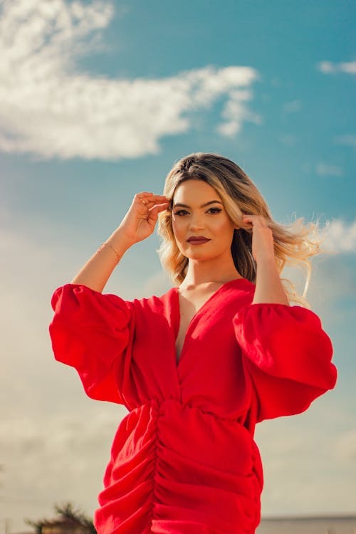 Portrait Of a Blonde Woman In a Red Dress Against the Landscape