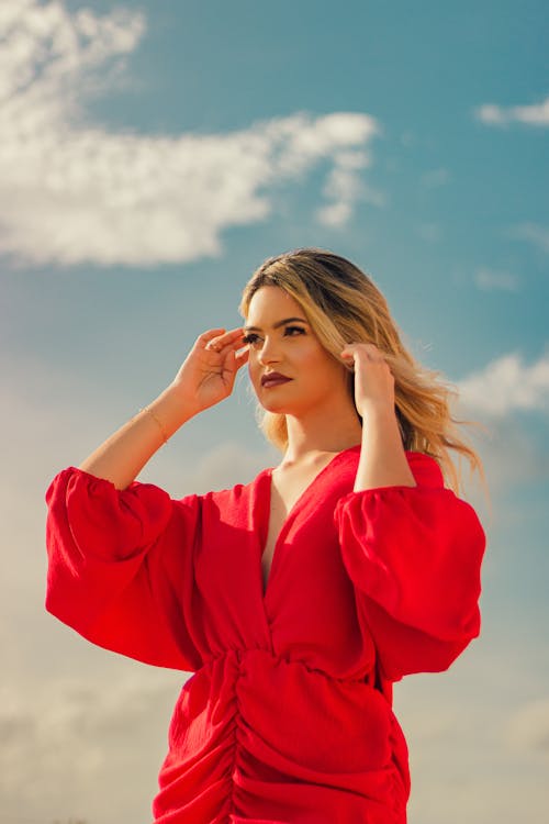 Portrait Of a Blonde Woman In a Red Dress Against the Landscape