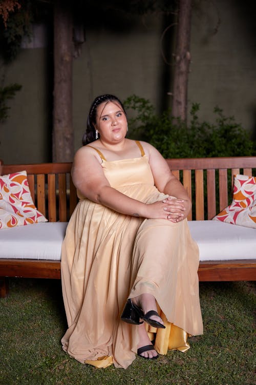 A Woman in a Beige Dress Sitting on a Bench