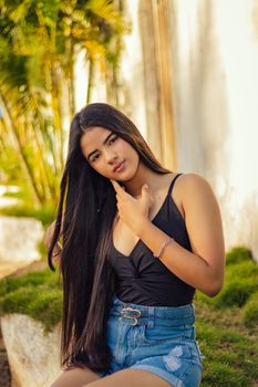Portrait of a young woman with long hair in casual attire outdoors, showcasing a relaxed summer vibe.